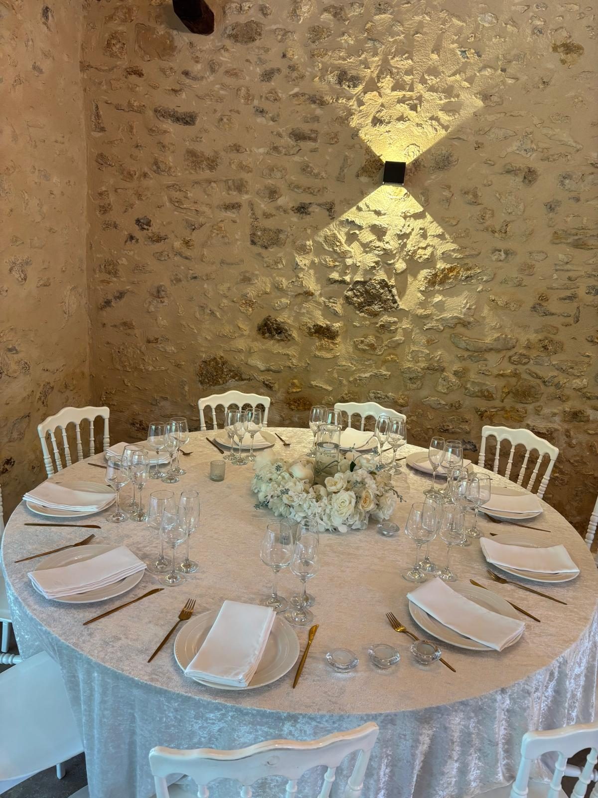 Table de réception dressée avec assiettes, verrerie et couverts dorés à Angervilliers, en Essonne